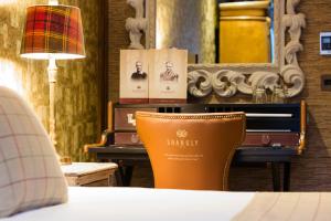 una sedia seduta di fronte a un tavolo con una lampada di The Shankly Hotel a Liverpool