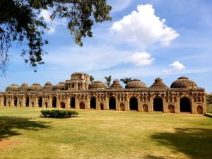 a building with domes on top of a field at Archana palace hampi in Hampi