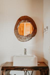 a bathroom with a sink and a mirror on the wall at Chalés Bosque das Oliveiras in Urubici