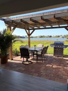 eine Terrasse mit einem Tisch, Stühlen und einem Grill in der Unterkunft Lake Marlin Villa 2 in Port Charlotte