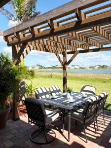 eine Terrasse mit einem Tisch und Stühlen unter einer hölzernen Pergola in der Unterkunft Lake Marlin Villa 2 in Port Charlotte