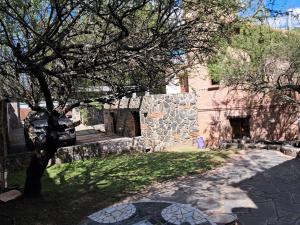 een boom voor een gebouw met een stenen muur bij Lagriega in Cuesta Blanca +4 foto's