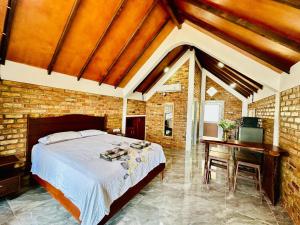 a bedroom with a bed and a desk in a brick wall at La Seahorse Homestay, private villa sea view Sebong Pereh, Bintan Island in Sebungpelangka