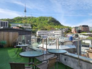 un balcone con tavoli e sedie e vista sulla città di 2 rooms for 7, Young House a Seul