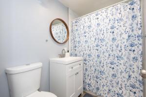 a bathroom with a toilet and a blue and white floral shower curtain at Spacious 3 Bedroom 2 Bathroom Apartment with Free Onsite Parking in Los Angeles +23 photos