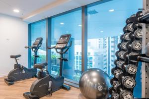 - une salle de sport avec 3 vélos d'exercice et une grande fenêtre dans l'établissement River View Central Brisbane 2-Bedroom Apartment, à Brisbane