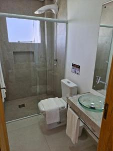a bathroom with a shower and a toilet and a sink at Palo Santo - Praia do Rosa in Praia do Rosa +32 photos