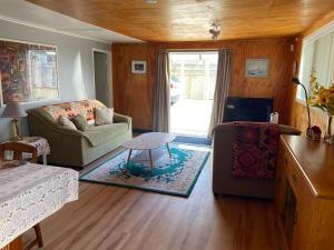 a living room with a couch and a table at Sunflower Cottage in Whakatane