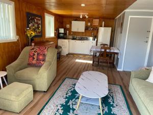 a living room with a couch and a table at Sunflower Cottage in Whakatane
