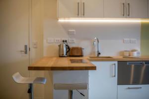 a kitchen with white cabinets and a counter top at Cumberland Street deluxe apartment No1 in Dunedin
