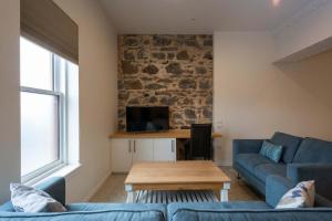 a living room with a blue couch and a table at Cumberland Street deluxe apartment No1 in Dunedin