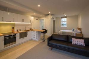 a kitchen and living room with a couch and a bed at Cumberland Street deluxe apartment No3 in Dunedin