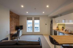 a living room with a couch and a table and a kitchen at Cumberland Street deluxe apartment No3 in Dunedin