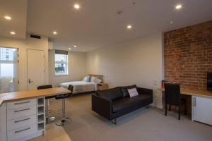 ダニーデンにあるCumberland Street deluxe apartment No2のデスク付きの部屋、ベッド付きのベッドルーム1室が備わります。