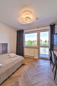 ワルシャワにあるPIleckiego 59 Studio z Balkonem Bezpłatny Parking By Perfect Apartのベッドと大きな窓のある寝室