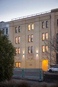 a large building with a car parked in front of it at Cumberland Street deluxe apartment No5 in Dunedin