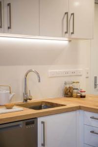 a kitchen with a sink and white cabinets at Cumberland Street deluxe apartment No5 in Dunedin