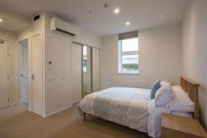 a bedroom with a large bed and a window at Cumberland Street deluxe apartment No5 in Dunedin +3 photos