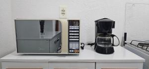 a microwave sitting on a counter next to a coffee maker at Doce refúgio - Aconchegante e completo in Uberaba