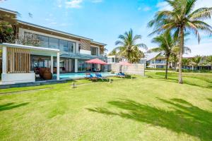 a house with a yard with a pool and palm trees at Danang Villas Complex in Da Nang