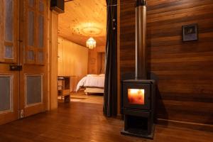 a wood stove in a room with a bedroom at Casita Boutique en Cachagua, vista al mar y calma in Cachagua