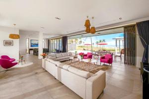 a living room with a large couch and pink chairs at Danang Villas Complex in Da Nang