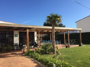 un pabellón de madera con una palmera en un patio en Casa Del Mar Hotel & Apartaments, en Roses