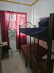 a room with two bunk beds and a window at Mel's Place Batangas Unit 4 Vista De Oro 2 Bedroom House w Free Parking, Google TV WIFI Netflix 4 Guests in Batangas City