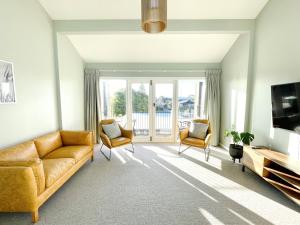 a living room with a couch and two chairs at The Waimate Lodges in Waimate