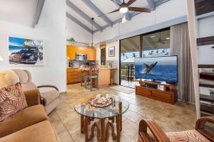 a living room with a couch and a tv at Ocean view with Loft in Kailua-Kona