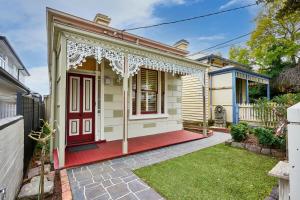 una casa con una puerta roja en un patio en Bowen Street Family Retreat with Pool, en Melbourne