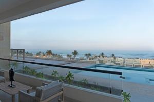 a balcony with a view of a swimming pool and the ocean at Beachfront apartment in Tampico