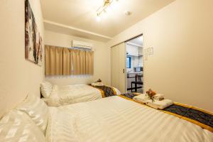 a bedroom with two beds with white sheets at 2mins walk to chidoribashi 12mins walk to nishikuzyou USJ Dotonbori nanba in Osaka +46 photos