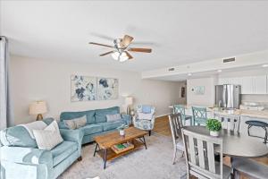 Una sala de estar con un sofá azul y una mesa. en Pelican Beach Resort 809, en Destin