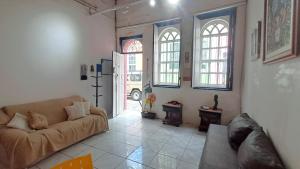 a living room with a couch and two windows at Casa inteira no Santo Antônio além do Carmo in Salvador