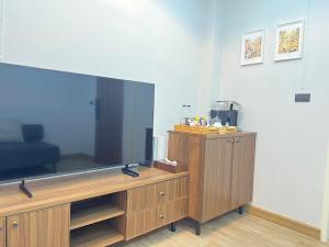 a large flat screen tv sitting on a wooden entertainment center at Hidden Room Bangsaen in Ban Thai Don (1) +38 photos
