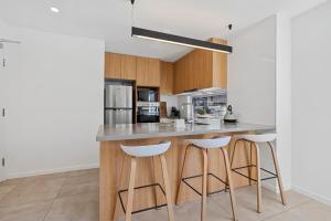 a kitchen with a island with bar stools at Private 3 Bedroom - 200m to the Beach in Mooloolaba