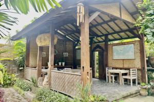 a pavilion with a table and chairs in a garden at Raja's Bungalows in Senggigi