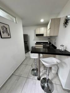 a kitchen with a counter and two stools in it at Hermoso apartamento completamente dotado in Floridablanca