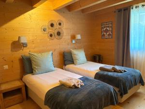 two beds in a room with wooden walls at Chalet La Renarde in Villars-sur-Ollon