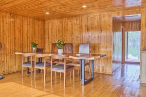 a dining room with wooden walls and a table and chairs at Lan Ha Floating Homestay in Cat Ba