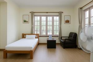 una camera con letto, sedia e ventilatore di Hotel Suva a Kathmandu
