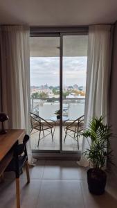 ビヤ・マリアにあるLa Riviera COPAHUE - CON COCHERAのテーブルと椅子のあるバルコニー付きの部屋