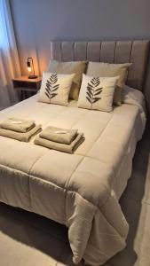 a bed with white sheets and pillows on it at LA RIVIERA Copahue - CON COCHERA in Villa María +12 photos