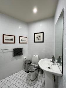 a white bathroom with a toilet and a sink at Bondi Stylish Bedroom Close to the Beach in Sydney +28 photos