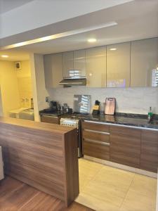 a large kitchen with a counter top in a room at Departamento Premium amplio y moderno - zona Cine Center in Cochabamba