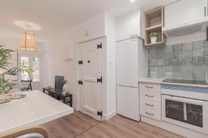 a kitchen with white cabinets and a white refrigerator at Stylish apartment in the heart of Lisbon in Lisbon +4 photos