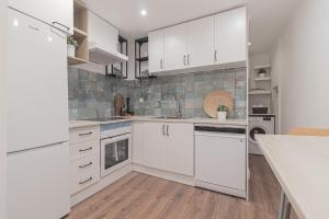 a kitchen with white cabinets and white appliances at Stylish apartment in the heart of Lisbon in Lisbon