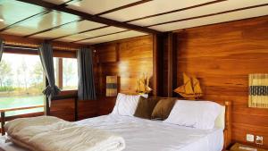 a bedroom with a bed in a room with wooden walls at Gallia Phinisi Batam in Nagoya