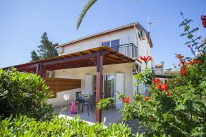 ein Haus mit einer Terrasse davor in der Unterkunft Larnaca Villa Marina in Meneou